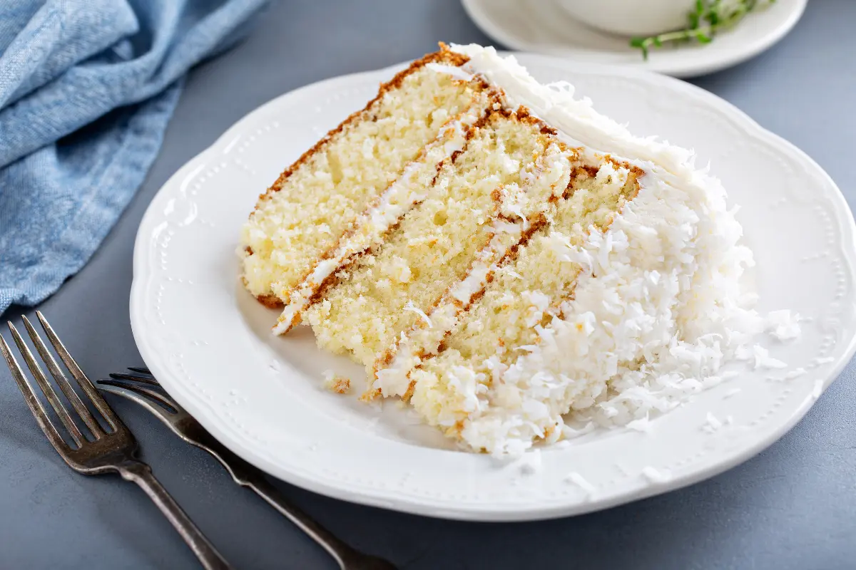 A vibrant image showcasing bottles of coconut, vanilla, and sweet cream flavor concentrates along with a vape pen, set against a backdrop of tropical palm leaves, capturing the essence of the coconut cake vape recipe.